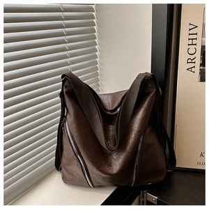 Dettaglio della borsa tote vintage in pelle plissettata marrone con zip argentate