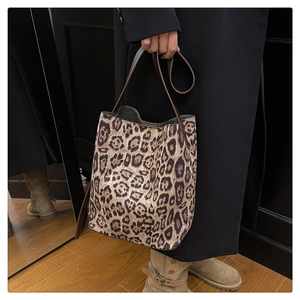 Close-up of leopard print suede tote bag with brown leather strap and soft texture