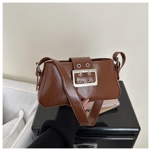 Detail of vintage brown shoulder bag with polished PU leather and silver square metal buckle