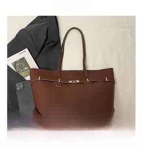 Detail view of large dark brown leather tote bag with elegant gold buckle and shoulder strap