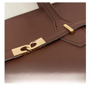 Detail of premium brown leather bag showing gold buckle and precise stitching craft