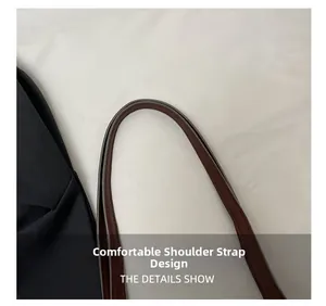 Close-up of comfortable brown leather shoulder strap and fine stitching on the black tote bag