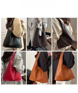 Sac fourre-tout minimaliste en cuir en plusieurs couleurs porté par un mannequin chic