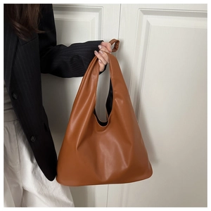 Détail d'un cabas minimaliste en similicuir caramel avec anse triangulaire intégrée