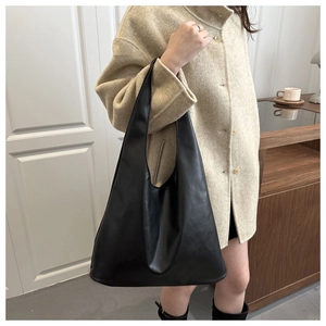 Détail d'un grand sac cabas hobo noir en cuir synthétique avec une finition lisse chic