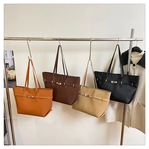 Detail view of large shoulder tote bags in multiple colors on a retail store display