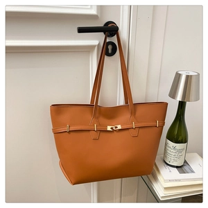 Detail of caramel tote bag showing golden buckle and premium faux leather texture