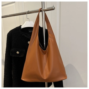 Détail du grand sac cabas en cuir marron avec poignée intégrée sur un présentoir