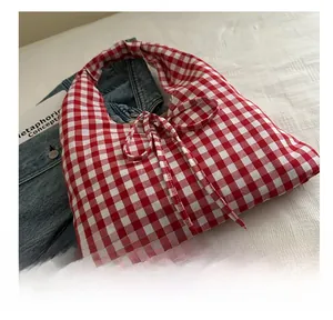 Detailed view of red and white plaid canvas tote bag with decorative ribbon bow