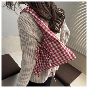 Detail view of red and white checkered fabric tote bag with a soft decorative side bow