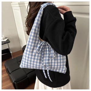 Detail of blue and white gingham tote bag featuring a side bow tie and soft cotton texture