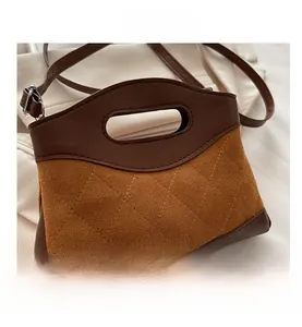 Detail of diamond quilted texture and contrast brown leather stitching on a handbag