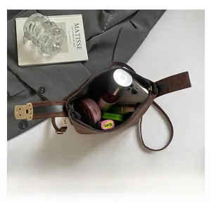 Interior view showing capacity of brown nylon shoulder bag with daily essentials