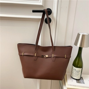 Fashionable dark brown leather tote bag with gold hardware shown in a lifestyle setting