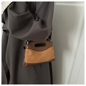 Detail of brown quilted leather bag with suede patchwork and hollow handle design