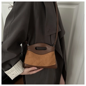 Brown quilted suede handbag shown with a dark trench coat for a stylish autumn look