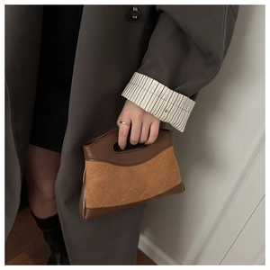 Detail of caramel suede quilted handbag featuring integrated handle and brown leather trim