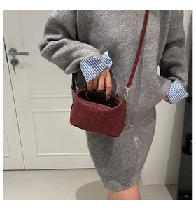Detail of dark red leopard print shoulder bag worn with a casual gray knit outfit