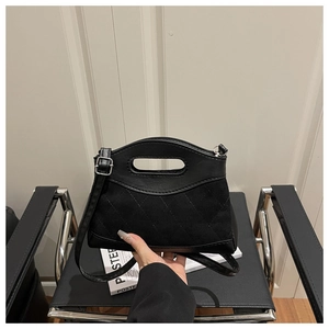 Detail of suede and smooth leather patchwork handbag with quilted pattern and handle