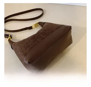 Detail showing precise stitching and leopard print texture on brown shoulder bag