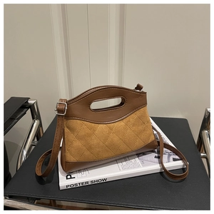 Detail of the suede and leather patchwork handbag featuring a hollow oval handle