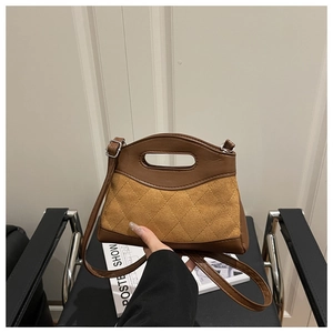 Close-up of brown suede and smooth leather patchwork bag with diamond quilted texture