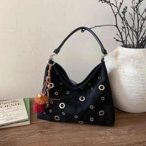 Chic black suede tote bag with silver metal eyelets and colorful tassel charm