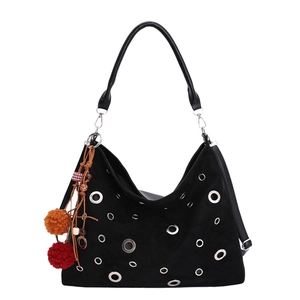 Minimalist black tote bag with silver metal eyelets and a colorful plush charm