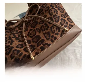 Detail of leopard print tote bag showing precise stitching and leather trim accents