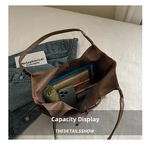 Detailed view of spacious coffee brown tote bag holding a tablet, books, and umbrella