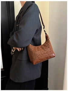Detail of leopard print hobo bag showing the pattern and brown leather stitching
