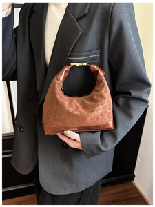 Close-up of leopard pattern embossed brown hobo bag with qaohse embroidery detail