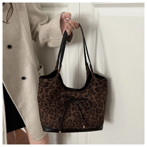 Detailed view of the leopard print tote bag featuring black leather trim and bow detail