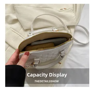 Top view detail of white quilted handbag interior showing space for phone and wallet
