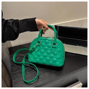 Close-up of vibrant green shell handbag with embossed quilted texture and gold hardware