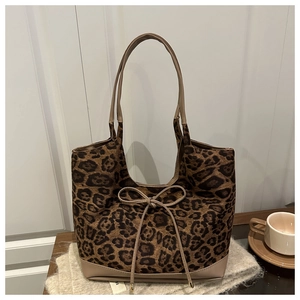 Detail of leopard print tote bag with bow detail on a cozy knit blanket background
