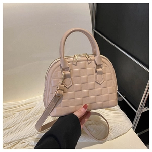 Detail of beige PU leather handbag with checkered texture and gold zipper hardware