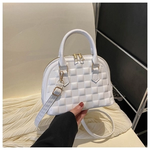 Detailed view of white semi-circular handbag with textured square embossing and gold hardware