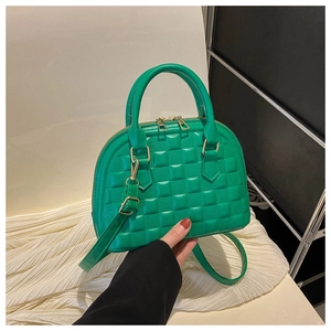 Macro shot of green quilted pattern and gold hardware on a stylish tote bag for women