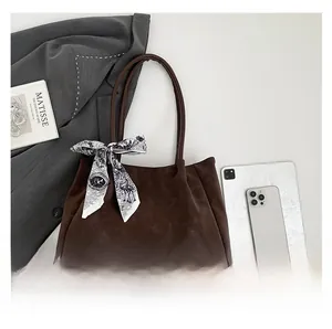 Top view of large brown faux suede tote bag with silk scarf for daily office commute