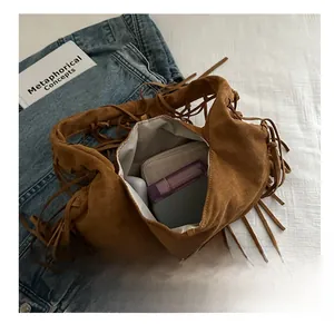 Brown suede tassel shoulder bag with spacious interior showing daily essentials