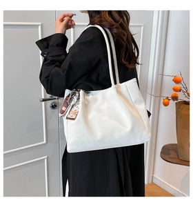Detailed side view of a large white tote bag with silk scarf and slim shoulder straps
