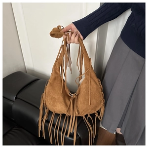 Macro shot of brown suede hobo bag featuring dense fringe tassels and soft crescent shape