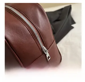 Close-up of smooth metal zipper and textured dark brown faux leather on retro shoulder bag