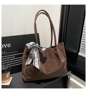 Close-up of brown matte tote bag featuring stylish printed silk scarf and slender straps