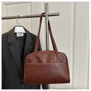 Detail of minimalist brown PU leather tote bag with shoulder straps and front pocket