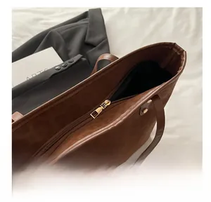 Close-up of smooth golden metal zipper on a brown textured leather bucket bag
