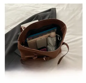 Macro view of a brown faux leather tote bag interior showing its large storage capacity