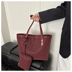 Detail of burgundy leopard print tote bag set featuring embossed texture and coin purse