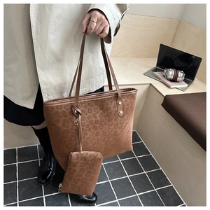 Detailed close-up of leopard print tote bag with matching zippered pouch and soft texture